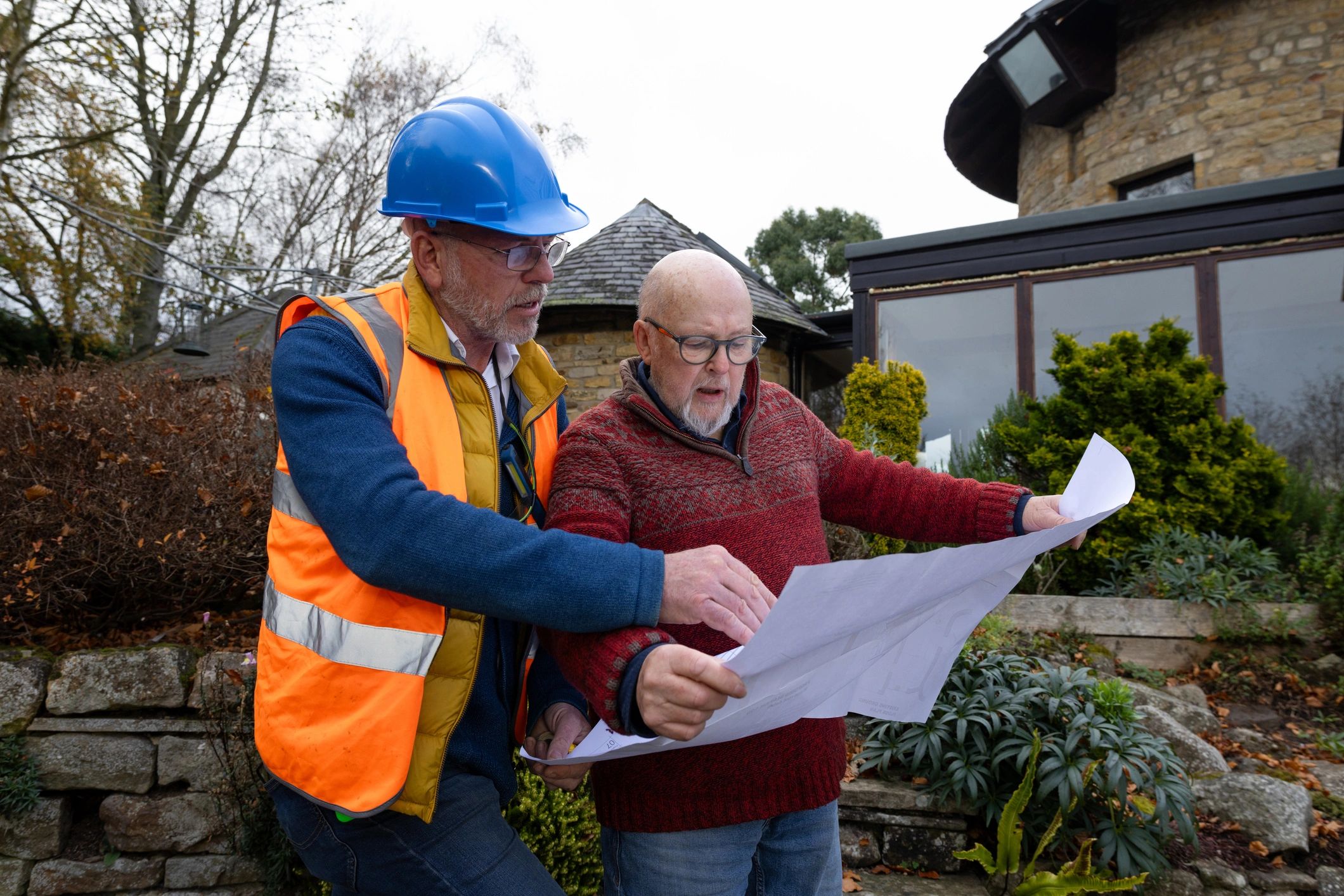 Builder and client reviewing construction plans together
