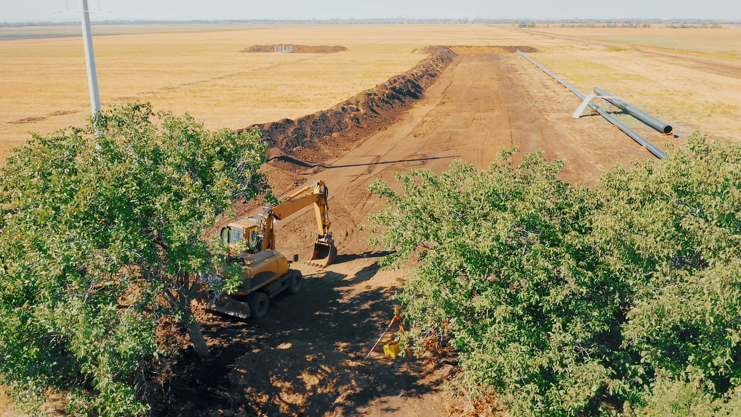 Excavator digging trench pipeline construction site